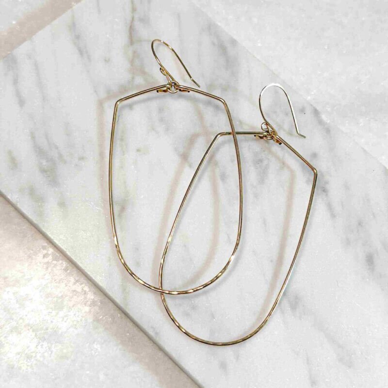 Joy Handcrafted, elongated geometric earrings in 14k gold fill or sterling silver, featuring a hammered bottom for added texture.