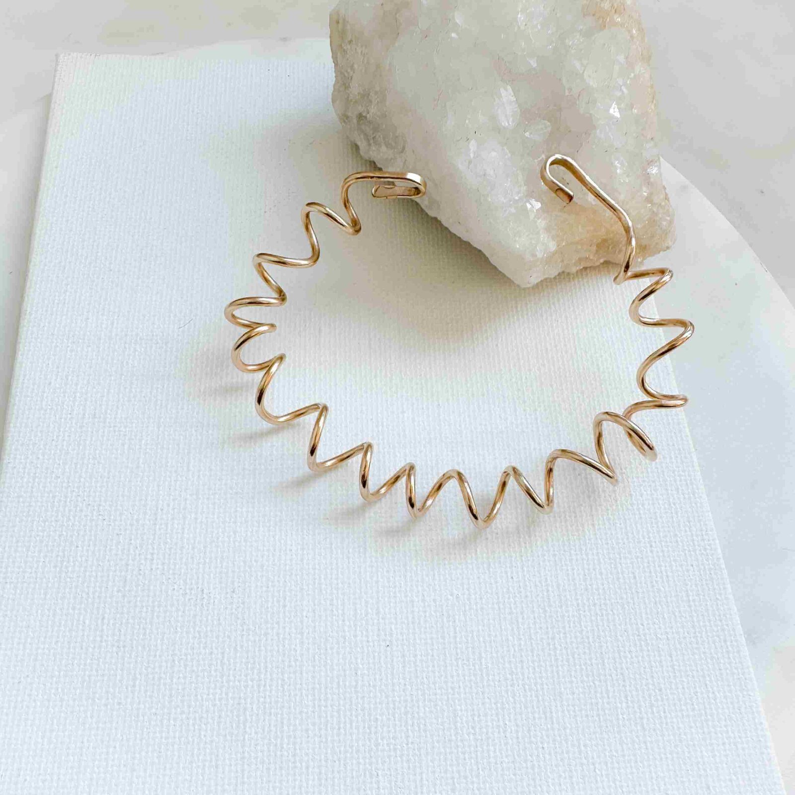 Sterling Silver or 14k gold filled spiral bracelet with handcrafted hook closure named the Quinn Bracelet on display.