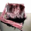 Mercer Fox Fur Clutch Bag with black and magenta fur, brass zipper closure, and magenta lining, displayed on a modern surface.