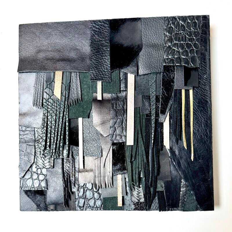Abstract wall art made from black and textured leather scraps on wood