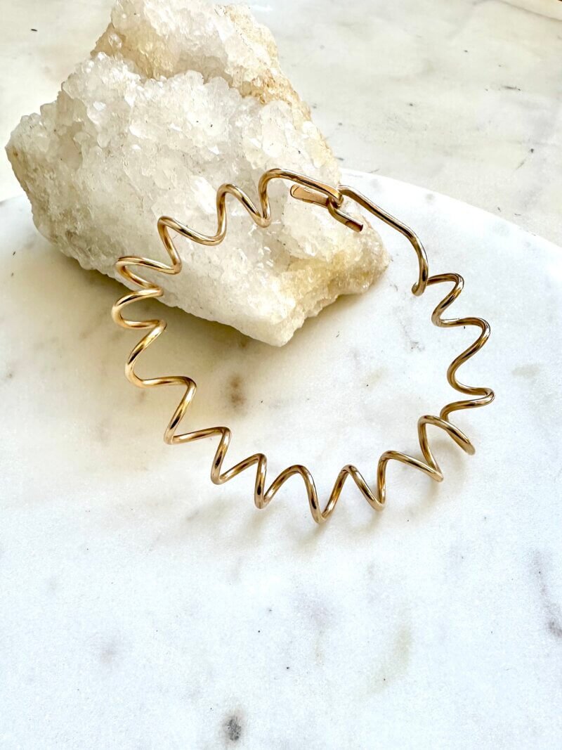 Sterling Silver or 14k gold filled spiral bracelet with handcrafted hook closure named the Quinn Bracelet on display.